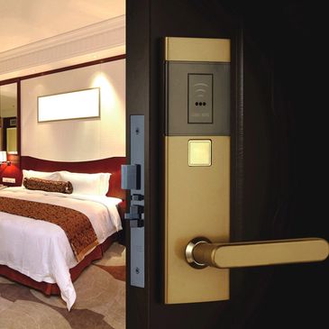 Modern hotel room door with electronic card lock and cozy interior.