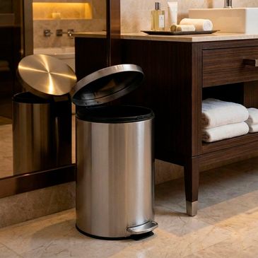 Modern stainless steel pedal trash can in a stylish bathroom.