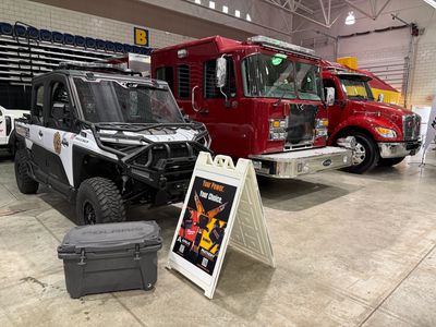 A Polaris fire utility vehicle and fire apparatus on the arena floor at the 2026 WV Fire Expo