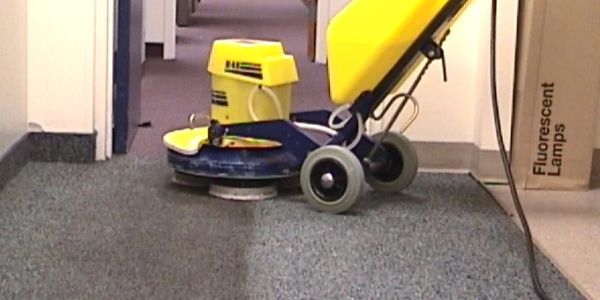 Floor cleaning machine polishing office carpet.