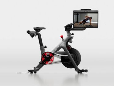Modern Peloton exercise bike with a large screen showing a workout instructor.