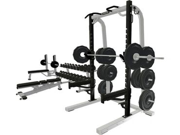 A multi-functional gym rack with weights and benches for strength training.