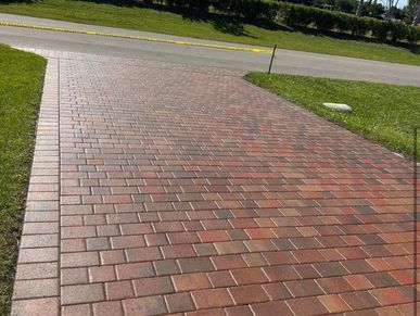 Red and brown brick driveway in a sunny outdoor setting.