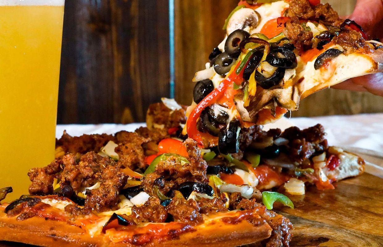 A picture of pizza and beer served in a tray