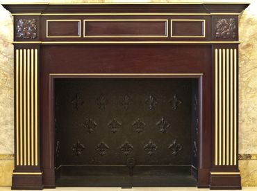 Walnut Traditional style fireplace surround with gold gilt, in building lobby. IINTER