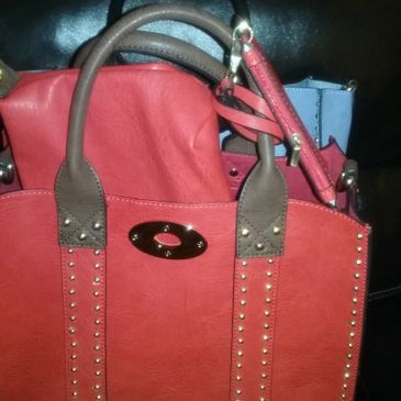 A picture of the red color bag with brown handles