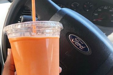 Hand holding a smoothie inside a Ford car.