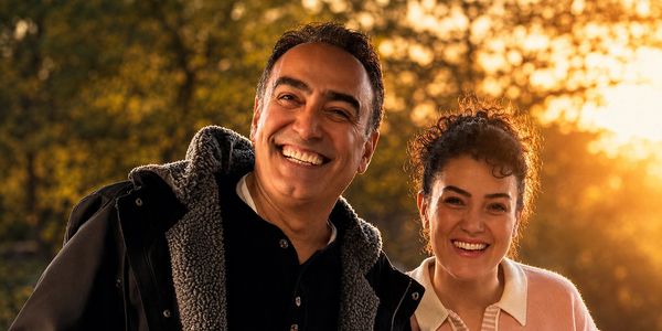 A joyful couple smiling warmly in the golden hour outdoors.