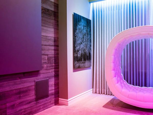 Modern room with purple lighting and circular furniture.