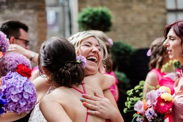 Bride and bridesmaid embrace