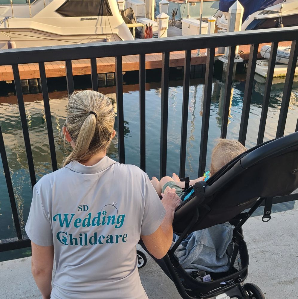 Woman from SD Wedding Childcare watching over a child in a stroller by the waterfront.