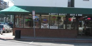 Store front of Albert’s Market green awning on Cambridge St.