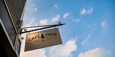 Café Du Pays sign with bright blue sky in the background