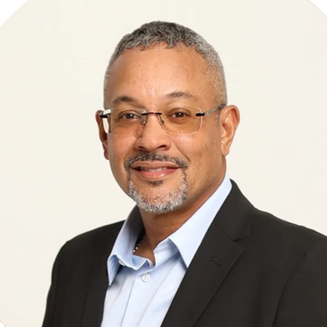 Professional man in glasses wearing a suit jacket and light blue shirt.