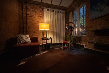 Cozy dimly-lit living room with exposed brick walls and warm lighting.