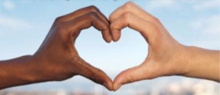 Two hands forming a heart shape against a blue sky.