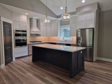 Modern kitchen with large island and stainless steel appliances.