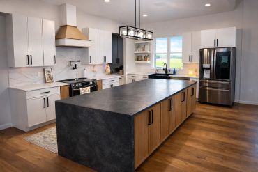 Modern kitchen with large island and wood floors.