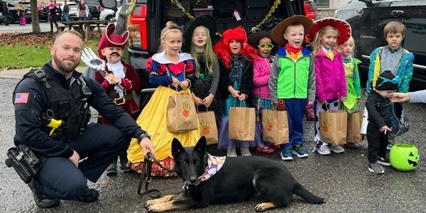 Photo of Officer Kam and K9 Stella at community Halloween Trunk or Treat event.