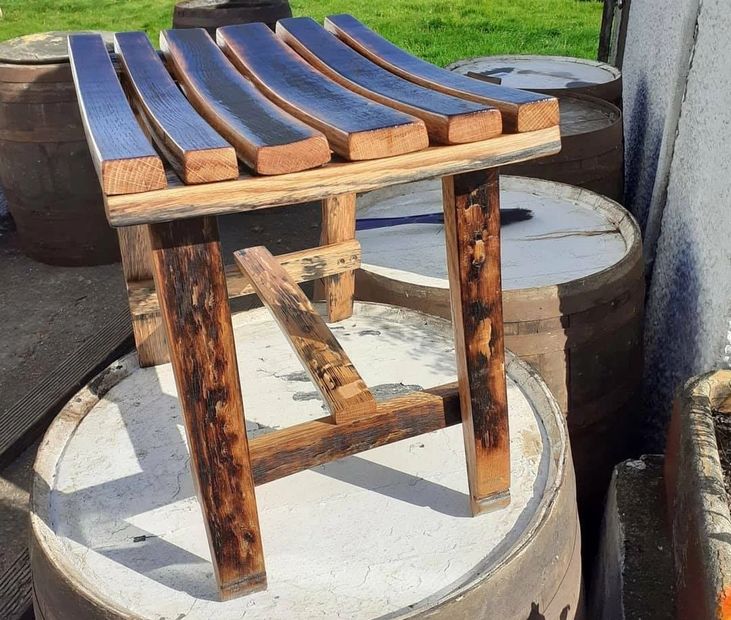 whisky barrel stave stool standing on top of a whisky barrel by wee dram barrel creations
