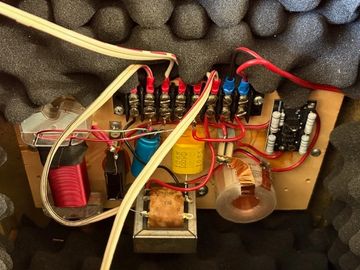Close-up of an electronic circuit board with wires and components in foam padding.