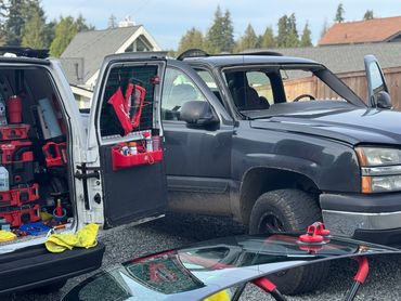 Truck windshield replaced with tools and new glass.