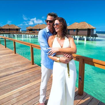 Couple standing on dock to overwater bungalow
