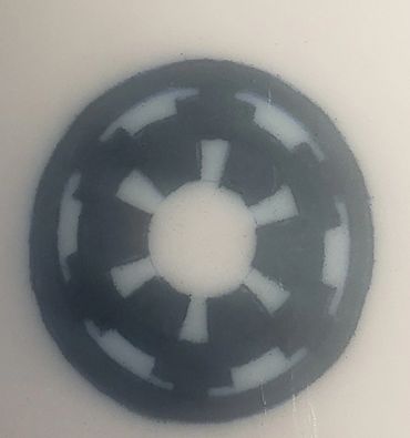 A circular symbol with a gear-like design in gray and white. Star Wars Imperial.