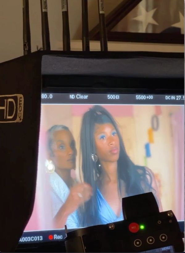 Two women are being filmed on a professional camera monitor.