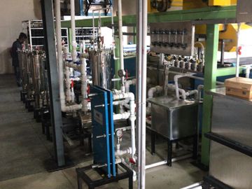 Industrial water treatment system with pipes and tanks in a factory setting.