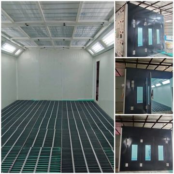 Industrial spray booth with grated flooring and black entry doors with windows.