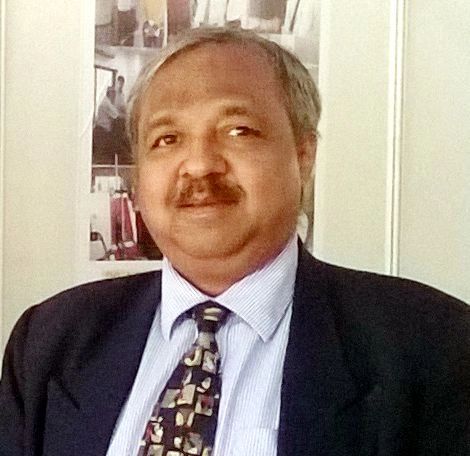 Man in suit with patterned tie posing indoors.