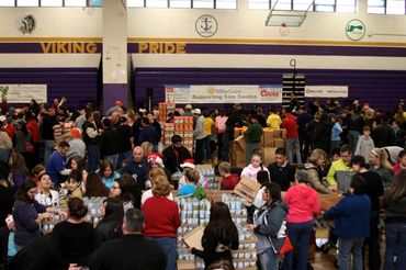Close-up of tables covered with donations with people