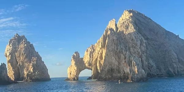 Rock formations in the sea under a clear blue sky.