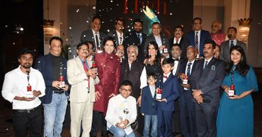 Group photo of award winners celebrating together with trophies and confetti.