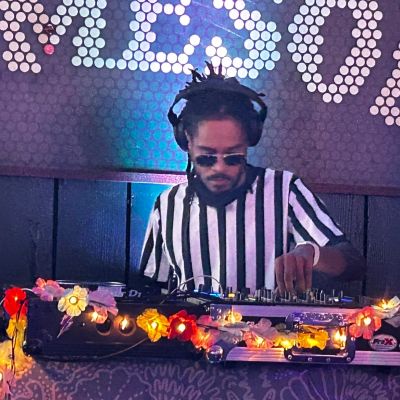 DJ in striped shirt mixing music with headphones.