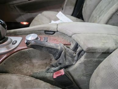 Dusty and worn car interior with a dirty handbrake and seats.