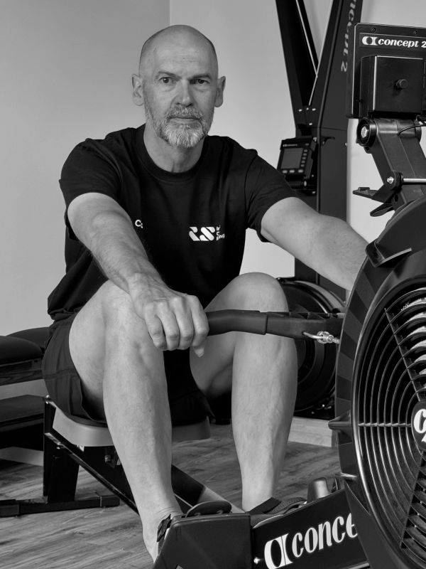 Man using a rowing machine at home gym.