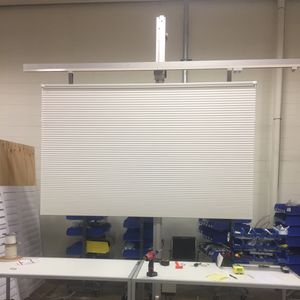 A Hunter Douglas blind repair that has been completed and hanging on on a blind hoist