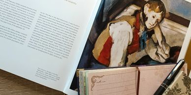 A collage of an illustrated book (text and image), a notebook, and a pen.