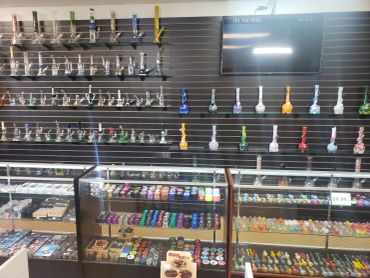 Assorted hand-blown glass pipes displayed on wall racks
