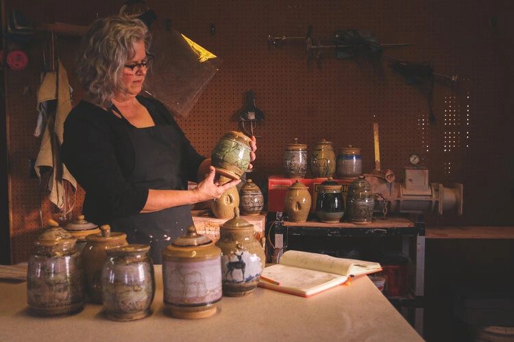 Cristy among her completed jars, each one honoring a wildlife-vehicle animal fatality on a nearby 10-mile stretch of road. Most of the victims are mule deer and pronghorn. (Photo GYC/Emily Reed.) Cristy among her completed jars, each one honoring a wildlife-vehicle animal fatality on a nearby 10-mile stretch of road. Most of the victims are mule deer and pronghorn. (Photo GYC/Emily Reed.)