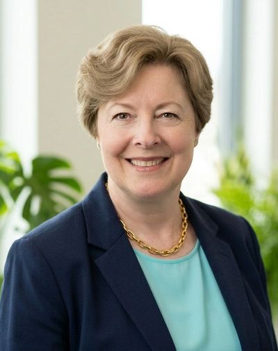 Professional woman smiling in business attire.