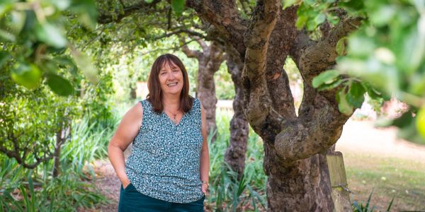 Woman standing happily in a garden.