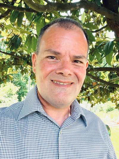 A serene landscape featuring a lake surrounded by mountains and trees during sunset.