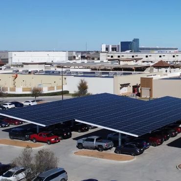 Parking lot with solar panel canopies over parked cars at a commercial area.