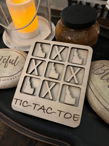 Tic tac toe board with x's and the state of Idaho for playing pieces.