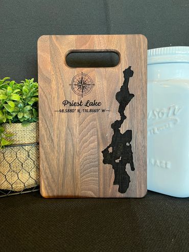 Walnut cutting board with priest lake and a compass on it