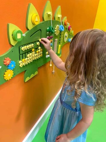 Girl in princess dress playing with sensory toys at Poppets Play Place West Knoxville Farragut