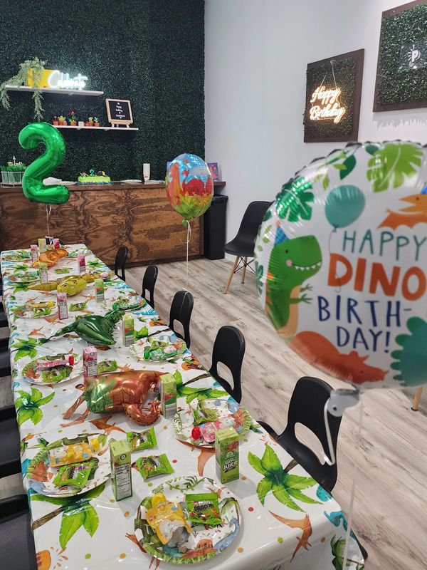 Colorful birthday party setup with balloons child seating tables party food birthday cake